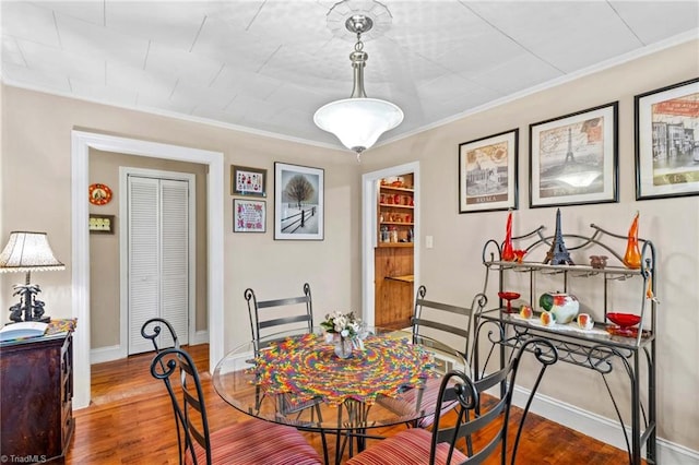 dining space featuring crown molding and hardwood / wood-style flooring