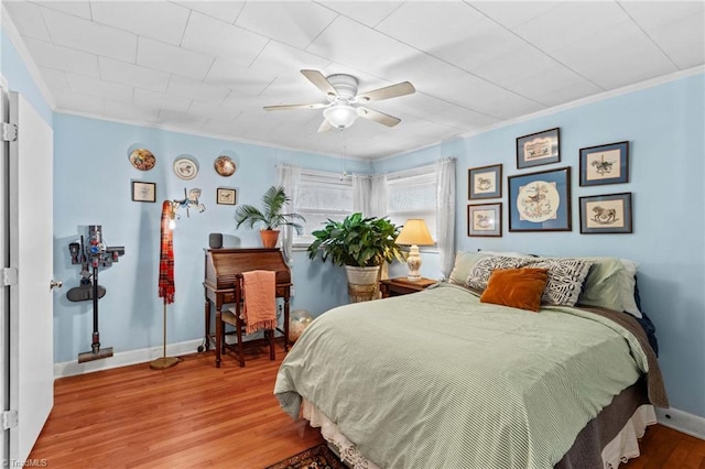 bedroom featuring ceiling fan, hardwood / wood-style flooring, and ornamental molding