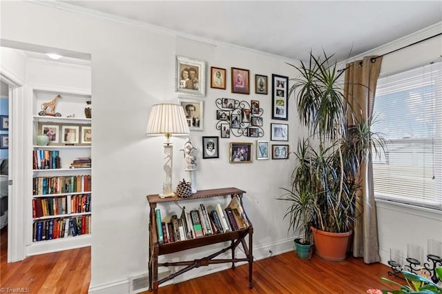 interior space with hardwood / wood-style floors and ornamental molding