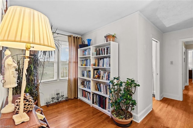 living area featuring crown molding and hardwood / wood-style flooring