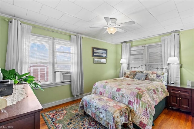 bedroom with light wood-type flooring, ceiling fan, and crown molding