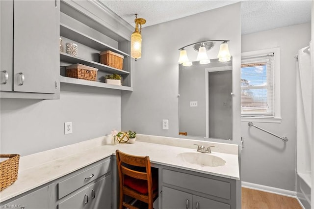 bathroom featuring vanity, wood-type flooring, a textured ceiling, and shower / bath combo with shower curtain