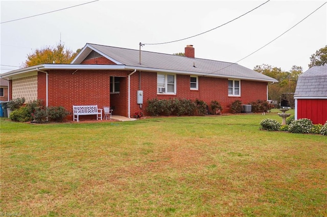 rear view of house featuring a yard and central AC unit