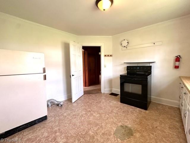 kitchen with freestanding refrigerator, black range with electric stovetop, crown molding, baseboards, and white cabinets