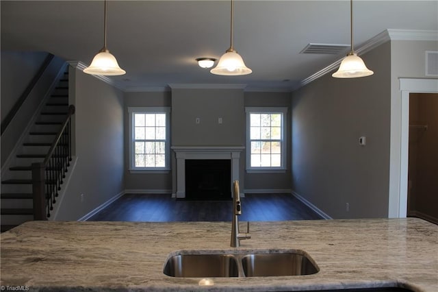 kitchen featuring sink, crown molding, pendant lighting, and dark wood-type flooring