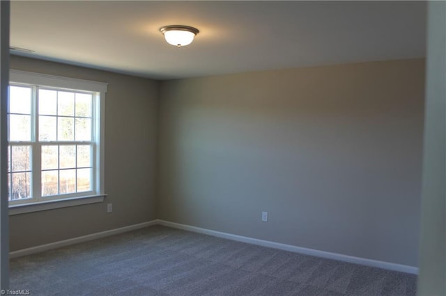 spare room with dark colored carpet