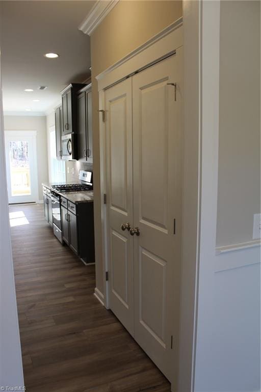 kitchen featuring crown molding, dark wood-type flooring, gray cabinetry, and stainless steel appliances