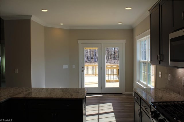 kitchen with light stone counters, plenty of natural light, and tasteful backsplash