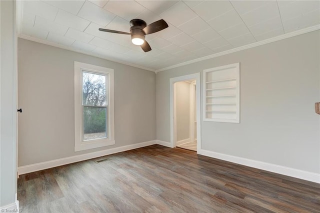 unfurnished room featuring dark hardwood / wood-style flooring, ceiling fan, built in features, and crown molding