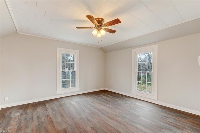 empty room with lofted ceiling, ceiling fan, dark hardwood / wood-style floors, and ornamental molding