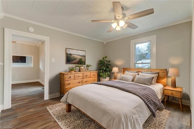 bedroom featuring ornamental molding, ceiling fan, and dark wood-type flooring