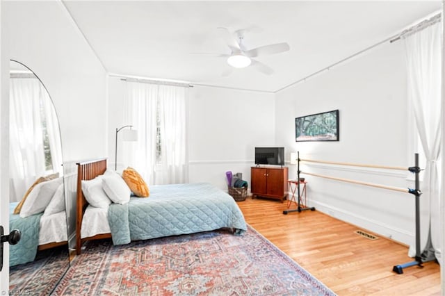 bedroom with visible vents, ceiling fan, and wood finished floors