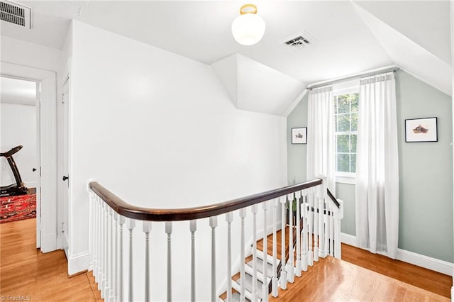 interior space featuring visible vents, wood finished floors, and an upstairs landing