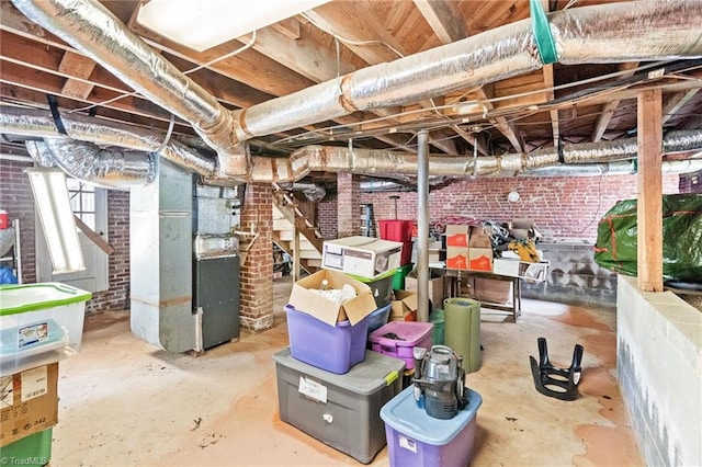 basement with heating unit and brick wall