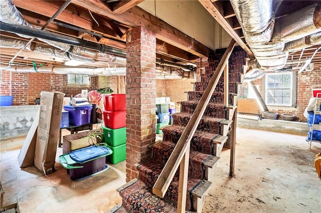 below grade area featuring stairs and brick wall