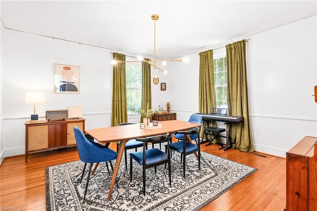 dining space featuring baseboards, hardwood / wood-style floors, and visible vents