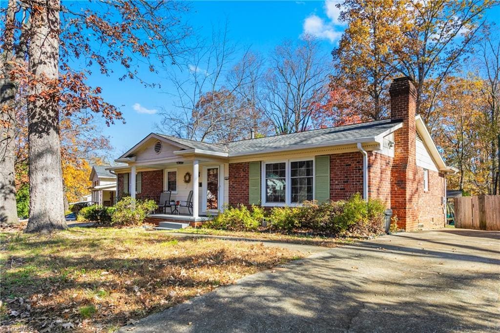 ranch-style home featuring a porch and a front lawn