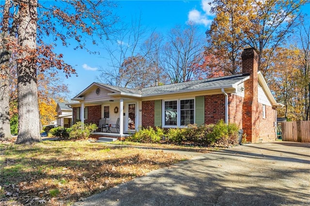 ranch-style home featuring a porch and a front lawn