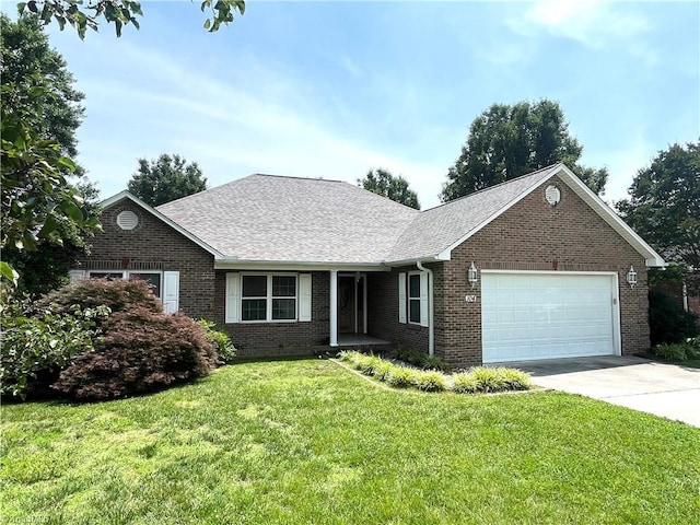 104 Autumn Hill Ct, Archdale, NC 27263 - view of front of home with an attached garage, brick siding, a front yard, driveway, and roof with shingles