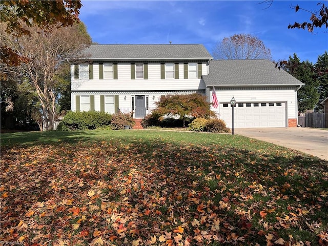 colonial home featuring a garage and a front lawn