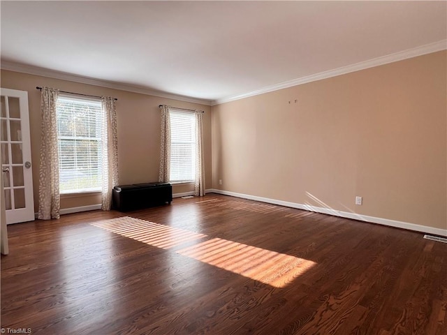 empty room with plenty of natural light, crown molding, and dark wood-type flooring