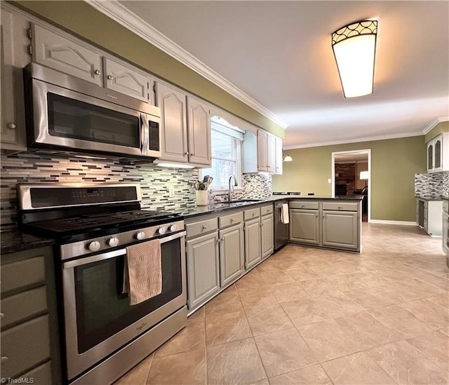 kitchen with appliances with stainless steel finishes, tasteful backsplash, gray cabinetry, ornamental molding, and sink