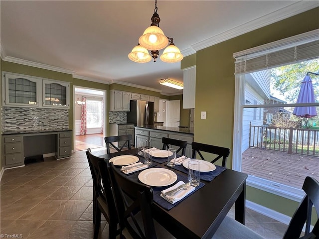 dining room featuring dark tile patterned flooring and crown molding