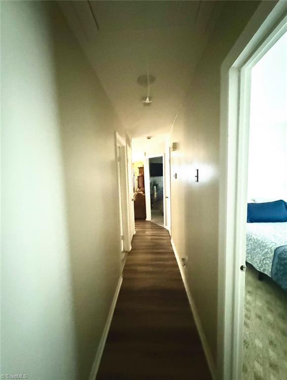5687 Bull Run Rd, Winston-Salem, NC 27106 - corridor with baseboards and dark wood-type flooring