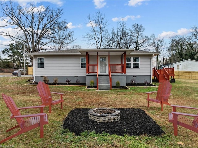 view of front of property featuring a front yard, a porch, and a fire pit