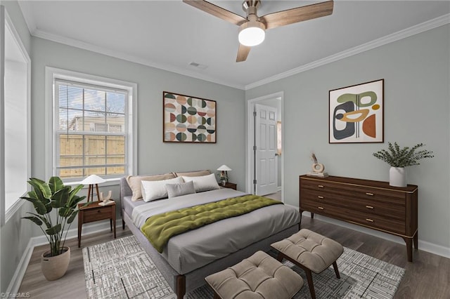 bedroom with ornamental molding, ceiling fan, and dark wood-type flooring