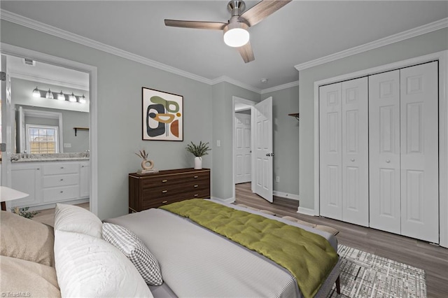 bedroom with connected bathroom, ceiling fan, wood-type flooring, a closet, and ornamental molding