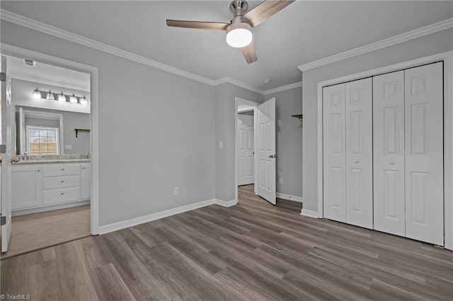 unfurnished bedroom featuring ceiling fan, light wood-type flooring, crown molding, and a closet