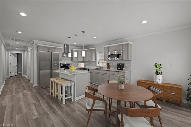 dining area with hardwood / wood-style flooring, ornamental molding, and sink