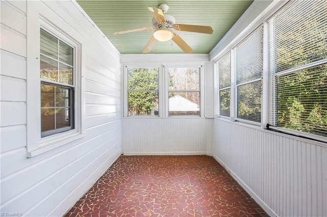 unfurnished sunroom with ceiling fan