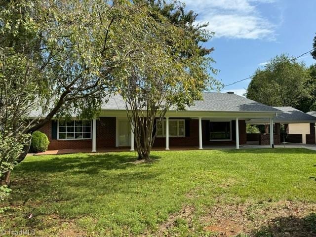 ranch-style house featuring a carport and a front lawn