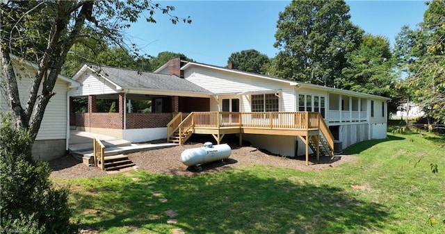 rear view of property featuring a lawn and a wooden deck