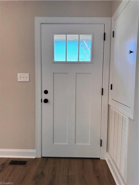 entryway with dark wood-type flooring, visible vents, and baseboards