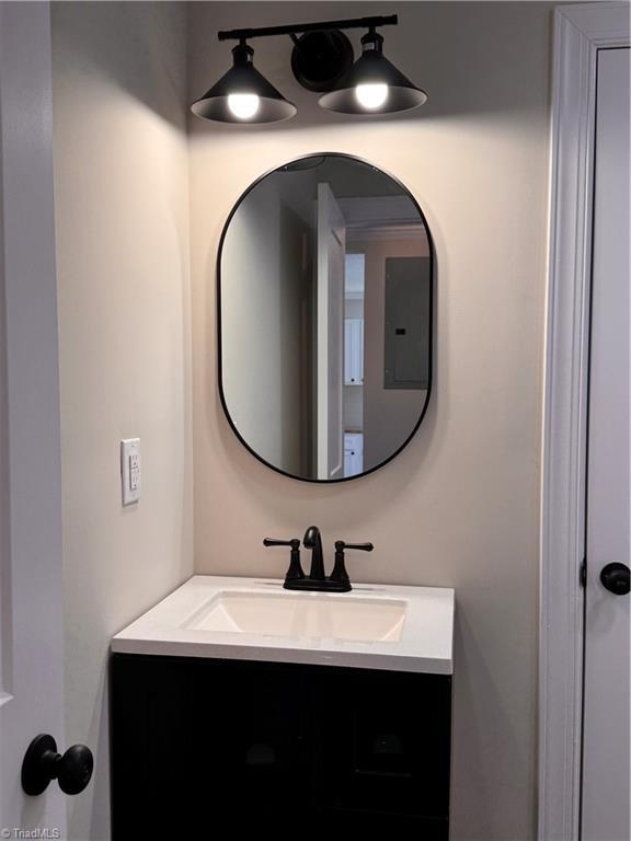 bathroom featuring electric panel and vanity