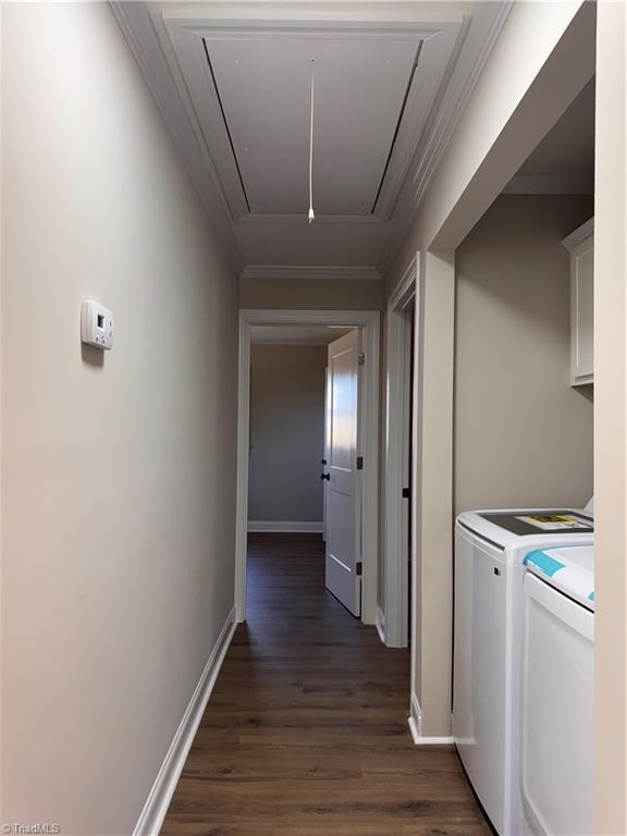 laundry area with dark wood-style flooring, attic access, ornamental molding, separate washer and dryer, and baseboards