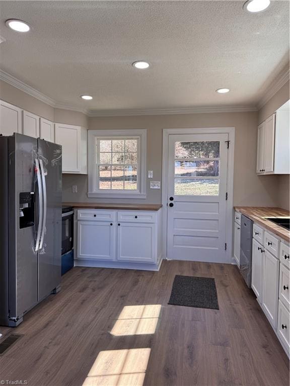 kitchen with white cabinets, dark wood-style floors, butcher block countertops, and stainless steel appliances