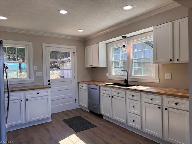 kitchen featuring white cabinets, butcher block countertops, appliances with stainless steel finishes, dark wood-type flooring, and hanging light fixtures