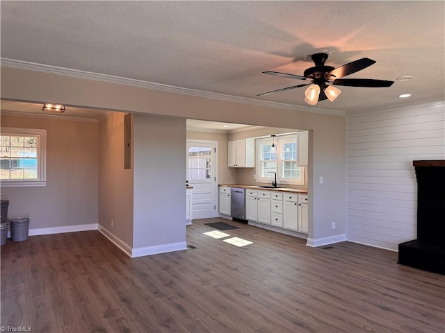 unfurnished living room featuring a textured ceiling, ornamental molding, dark wood finished floors, and a sink