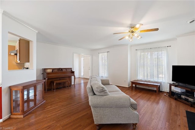 living area featuring crown molding, baseboards, ceiling fan, and hardwood / wood-style floors