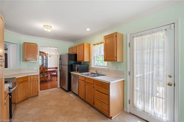 kitchen with an inviting chandelier, crown molding, light countertops, a sink, and stainless steel appliances