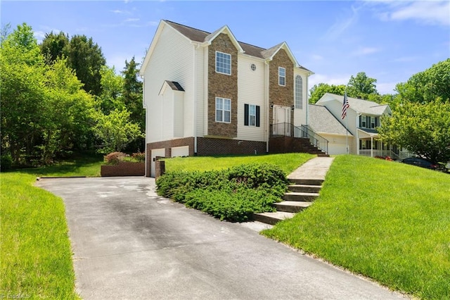 view of front of property featuring driveway, a front yard, a garage, brick siding, and stone siding