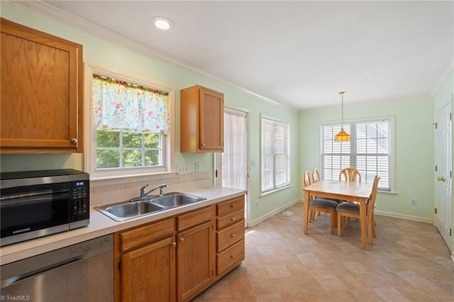 kitchen featuring crown molding, a sink, baseboards, and appliances with stainless steel finishes