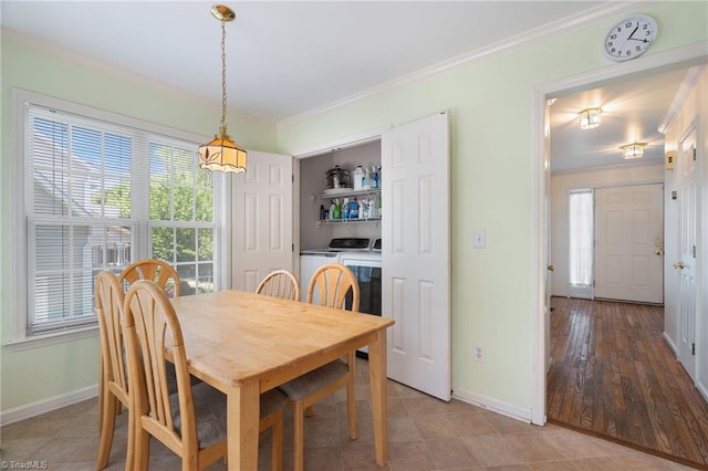 dining area featuring crown molding, baseboards, a wealth of natural light, and washer and dryer