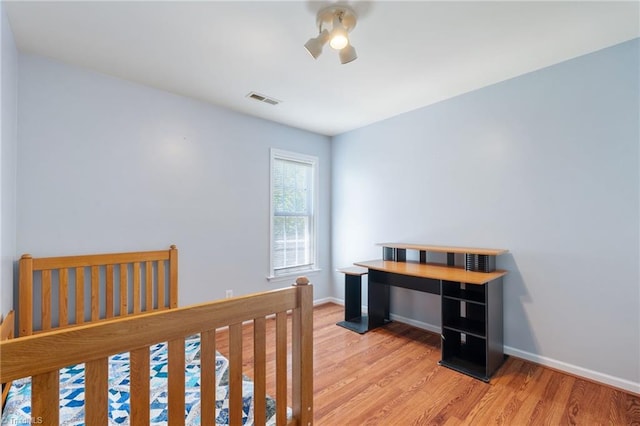 bedroom featuring baseboards, visible vents, ceiling fan, and light wood-style floors
