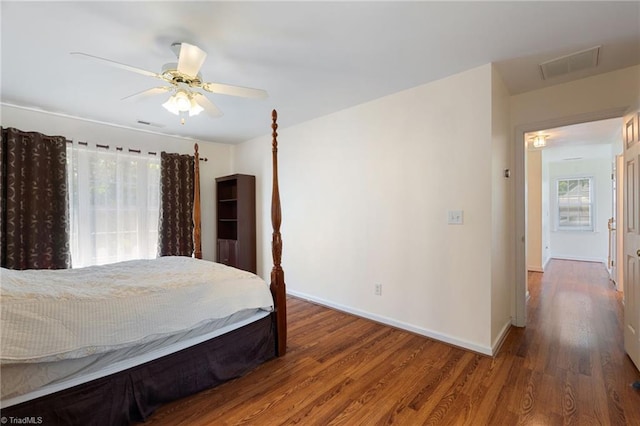 bedroom featuring ceiling fan, baseboards, visible vents, and wood finished floors