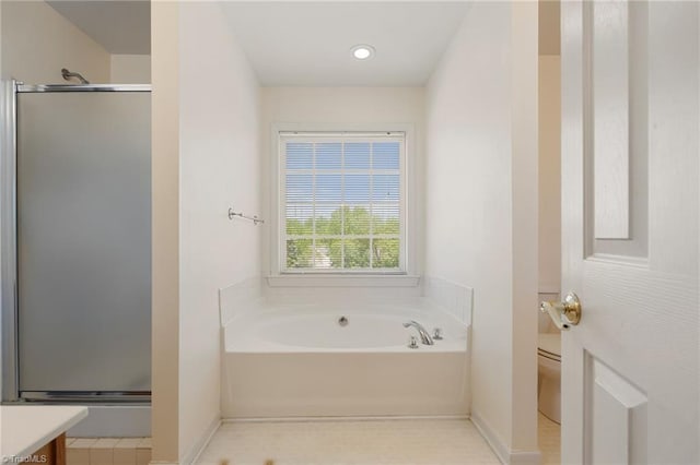 bathroom with a garden tub, vanity, toilet, baseboards, and a shower stall